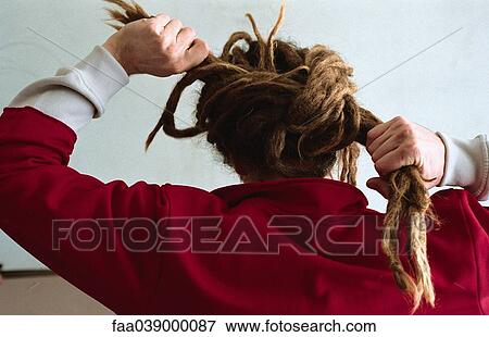 Man with long dreadlocks, tying them into bun, rear view View Large Photo Image Stock Photo - Man with long dreadlocks, tying them into bun, rear view. Fotosearch