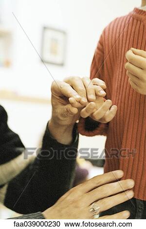 Stock Image - Person examining child's hand, cropped view. Fotosearch