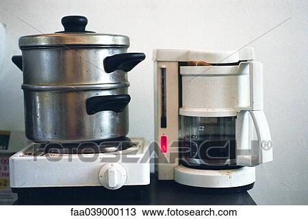 Steamer on hotplate set next to coffee maker on counter View Large Photo Image Stock Image - Steamer on hotplate set next to coffee maker on counter. Fotosearch