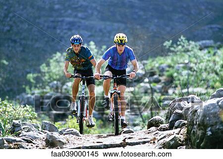 Stock Photography - Two men riding mountain bikes. Fotosearch