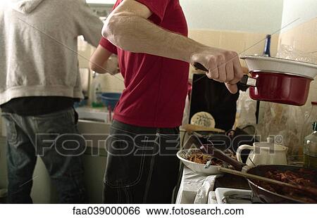 Two young men preparing food in kitchen View Large Photo Image Stock Photograph - Two young men preparing food in kitchen. Fotosearch
