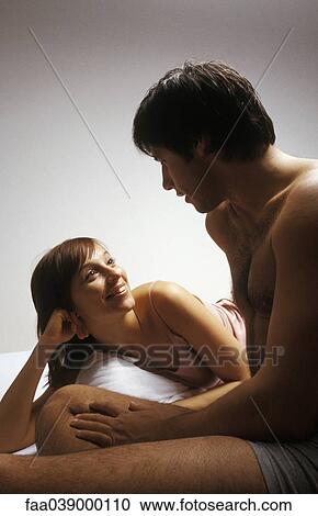 Young couple together in bed, chatting View Large Photo Image Stock Image - Young couple together in bed, chatting. Fotosearch
