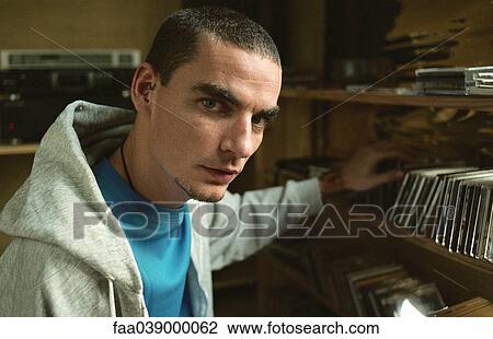 Young man selecting CD from collection on shelf View Large Photo Image Stock Image - Young man selecting CD from collection on shelf. Fotosearch