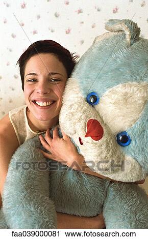 Young woman hugging teddy bear smiling at camera View Large Photo Image Stock Image - Young woman hugging teddy bear smiling at camera. Fotosearch