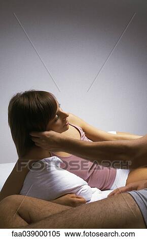 Young woman reclining on bed, man stroking her cheek View Large Photo Image Stock Photography - Young woman reclining on bed, man stroking her cheek. Fotosearch