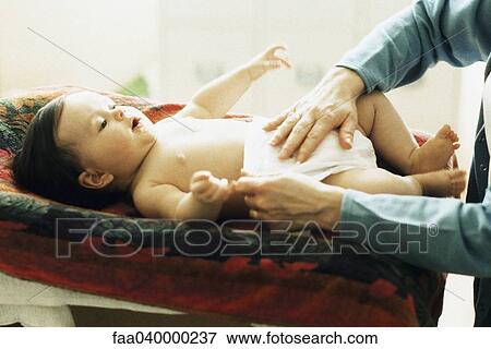 Baby having diaper changed View Large Photo Image Stock Photo - Baby having diaper changed. Fotosearch