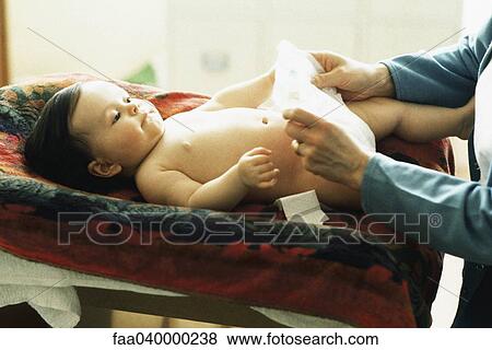 Baby having diaper changed View Large Photo Image Stock Photo - Baby having diaper changed. Fotosearch