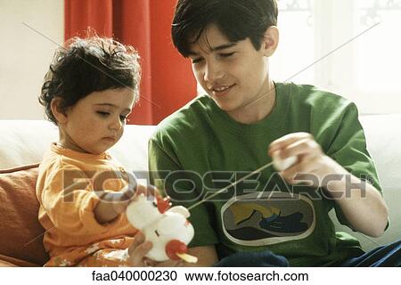 Boy playing with little sister and toy duck View Large Photo Image Stock Image - Boy playing with little sister and toy duck. Fotosearch