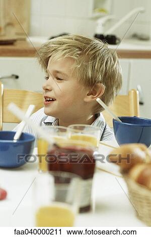 Boy sitting at table for breakfast View Large Photo Image Stock Image - Boy sitting at table for breakfast. Fotosearch