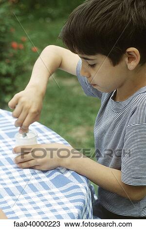 Boy sitting at table, stirring yogurt View Large Photo Image Stock Image - Boy sitting at table, stirring yogurt. Fotosearch
