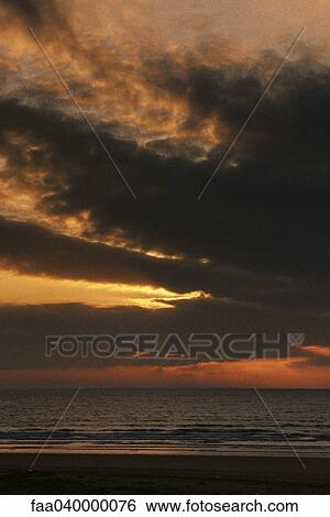 Cloud-covered sunset at beach View Large Photo Image Stock Photograph - Cloud-covered sunset at beach. Fotosearch