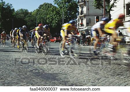 Cyclists racing on cobblestone street View Large Photo Image Stock Photo - Cyclists racing on cobblestone street. Fotosearch