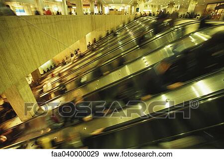 Escalators in crowded shopping mall View Large Photo Image Stock Photo - Escalators in crowded shopping mall. Fotosearch