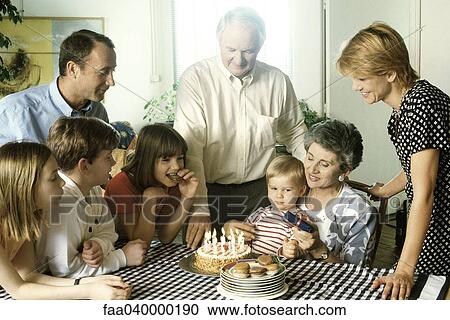 Family gathered around birthday cake View Large Photo Image Stock Image - Family gathered around birthday cake. Fotosearch
