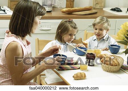 Family sitting at table for breakfast View Large Photo Image Stock Image - Family sitting at table for breakfast. Fotosearch