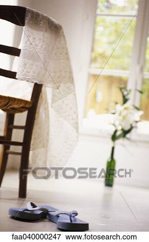 Flip-flops on floor, vase and table in background View Large Photo Image Stock Photo - Flip-flops on floor, vase and table in background. Fotosearch