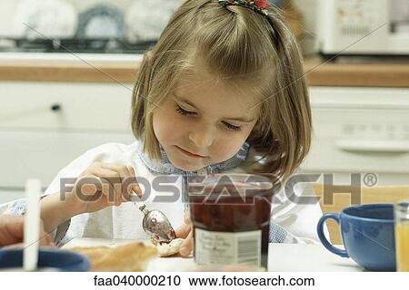 Girl putting jam on bread View Large Photo Image Stock Image - Girl putting jam on bread. Fotosearch