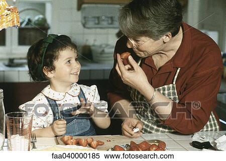 Grandmother and granddaughter cutting up strawberries, smiling at each other View Large Photo Image Stock Photography - Grandmother and granddaughter cutting up strawberries, smiling at each other. Fotosearch