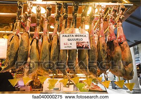 Stock Photography - Ham shoulders hanging in butcher's shop. Fotosearch