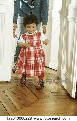Little girl walking, mother following behind View Large Photo Image Stock Photo - Little girl walking, mother following behind. Fotosearch