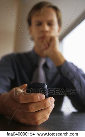 Man holding cell phone, low angle view View Large Photo Image Picture - Man holding cell phone, low angle view. Fotosearch