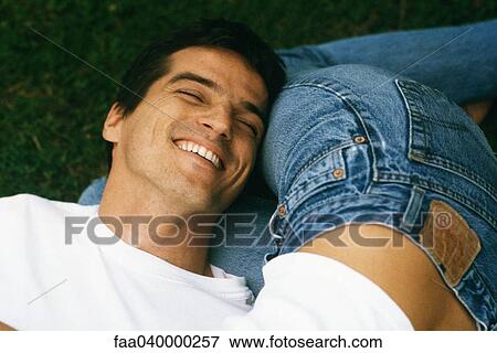 Man resting head on woman's legs, laughing, cropped View Large Photo Image Stock Photo - Man resting head on woman's legs, laughing, cropped. Fotosearch
