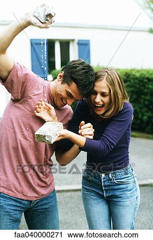 Man squeezing sponge, woman laughing, catching water with sponge View Large Photo Image Stock Image - Man squeezing sponge, woman laughing, catching water with sponge. Fotosearch