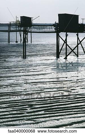 Stock Photo - Pier with fishing nets along coast. Fotosearch
