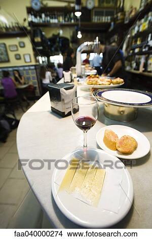 Plate of Manchego cheese, half finished glass of wine in tapas bar View Large Photo Image Picture - Plate of Manchego cheese, half finished glass of wine in tapas bar. Fotosearch