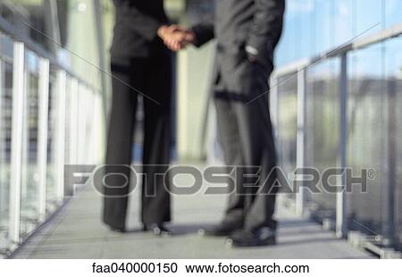 Professionals shaking hands, blurred, low section View Large Photo Image Stock Image - Professionals shaking hands, blurred, low section. Fotosearch