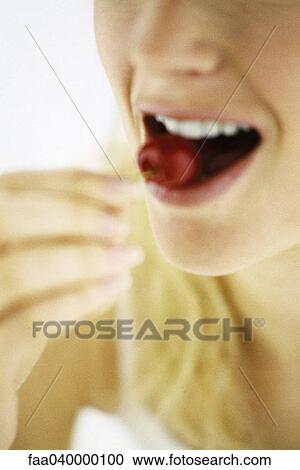 Woman biting into fruit View Large Photo Image Stock Image - Woman biting into fruit. Fotosearch