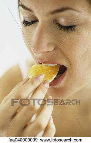Woman biting into fruit View Large Photo Image Stock Photo - Woman biting into fruit. Fotosearch