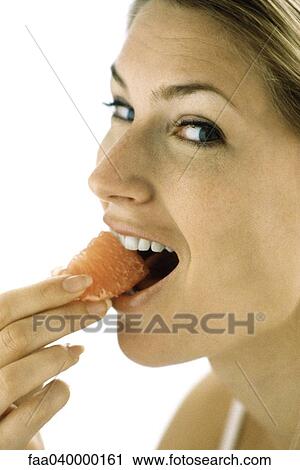 Stock Image - Woman eating grapefruit. Fotosearch