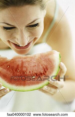Woman eating slice of watermelon View Large Photo Image Stock Image - Woman eating slice of watermelon. Fotosearch