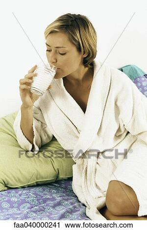 Woman in bathrobe drinking milk in bed View Large Photo Image Stock Image - Woman in bathrobe drinking milk in bed. Fotosearch