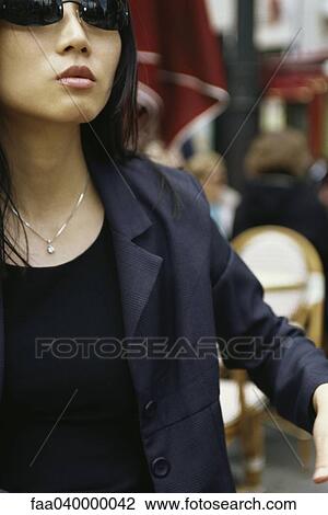 Stock Image - Woman in sidewalk cafe, cropped view. Fotosearch