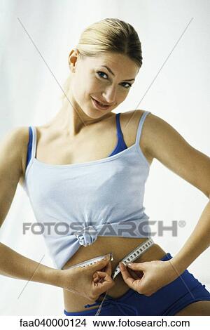 Woman in sports clothing, measuring waist View Large Photo Image Picture - Woman in sports clothing, measuring waist. Fotosearch