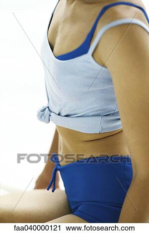 Stock Image - Woman in sports clothing, mid-section. Fotosearch