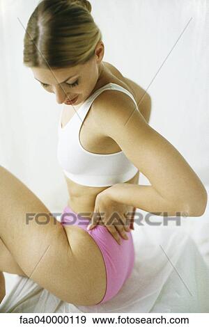 Woman in underwear, holding back, looking down View Large Photo Image Stock Photo - Woman in underwear, holding back, looking down. Fotosearch