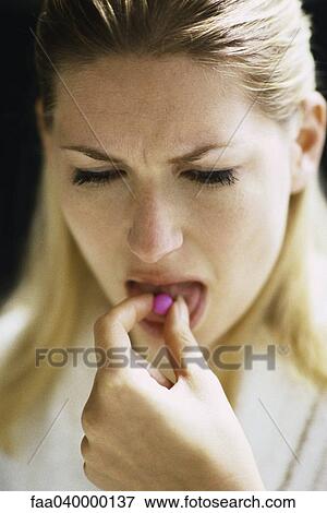 Woman placing pill on tongue View Large Photo Image Stock Photo - Woman placing pill on tongue. Fotosearch