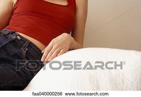 Woman relaxing on sofa, mid section View Large Photo Image Stock Photograph - Woman relaxing on sofa, mid section. Fotosearch