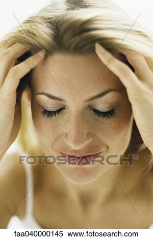 Stock Photography - Woman running hands through hair, eyes closed. Fotosearch