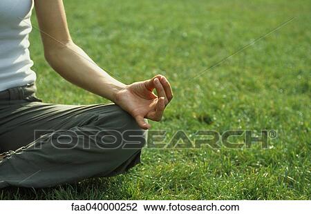 Woman sitting in lotus position on grass, cropped View Large Photo Image Stock Image - Woman sitting in lotus position on grass, cropped. Fotosearch