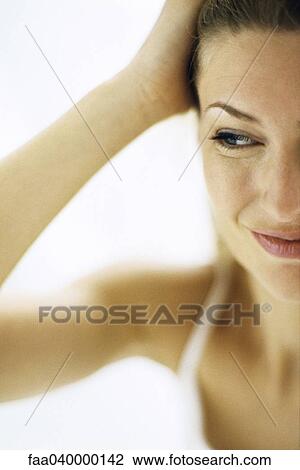 Stock Image - Woman touching head, looking away. Fotosearch