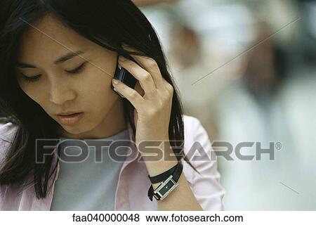 Woman using cell phone, looking down View Large Photo Image Stock Photo - Woman using cell phone, looking down. Fotosearch