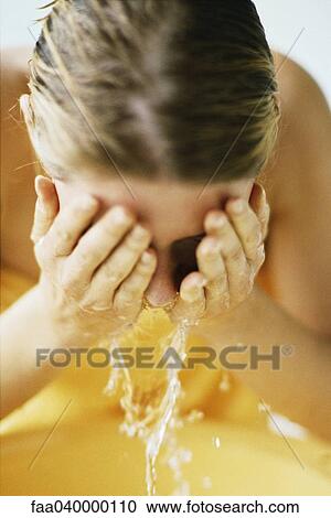 Woman washing face in bathroom sink View Large Photo Image Stock Image - Woman washing face in bathroom sink. Fotosearch
