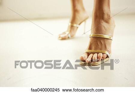 Stock Photography - Woman wearing high heels, cropped view of feet. Fotosearch