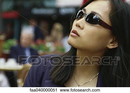 Woman wearing sunglasses, looking up View Large Photo Image Stock Image - Woman wearing sunglasses, looking up. Fotosearch