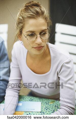 "Blonde woman wearing glasses, looking away" View Large Photo Image Stock Photograph - "Blonde woman wearing glasses, looking away". Fotosearch