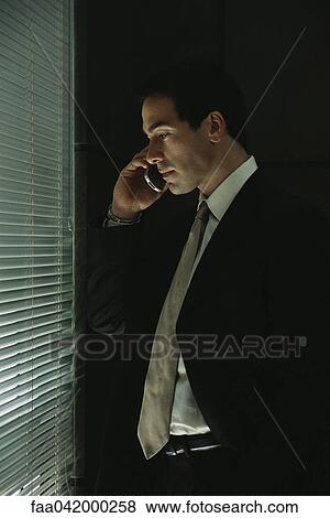 "Businessman using cell phone, looking through blinds out window" View Large Photo Image Stock Photo - "Businessman using cell phone, looking through blinds out window". Fotosearch